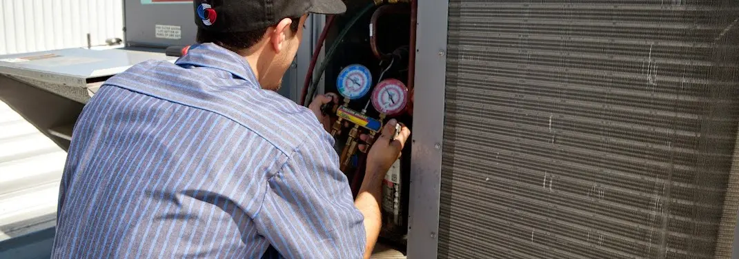 HVAC technician servicing a condenser unit in Valparaiso